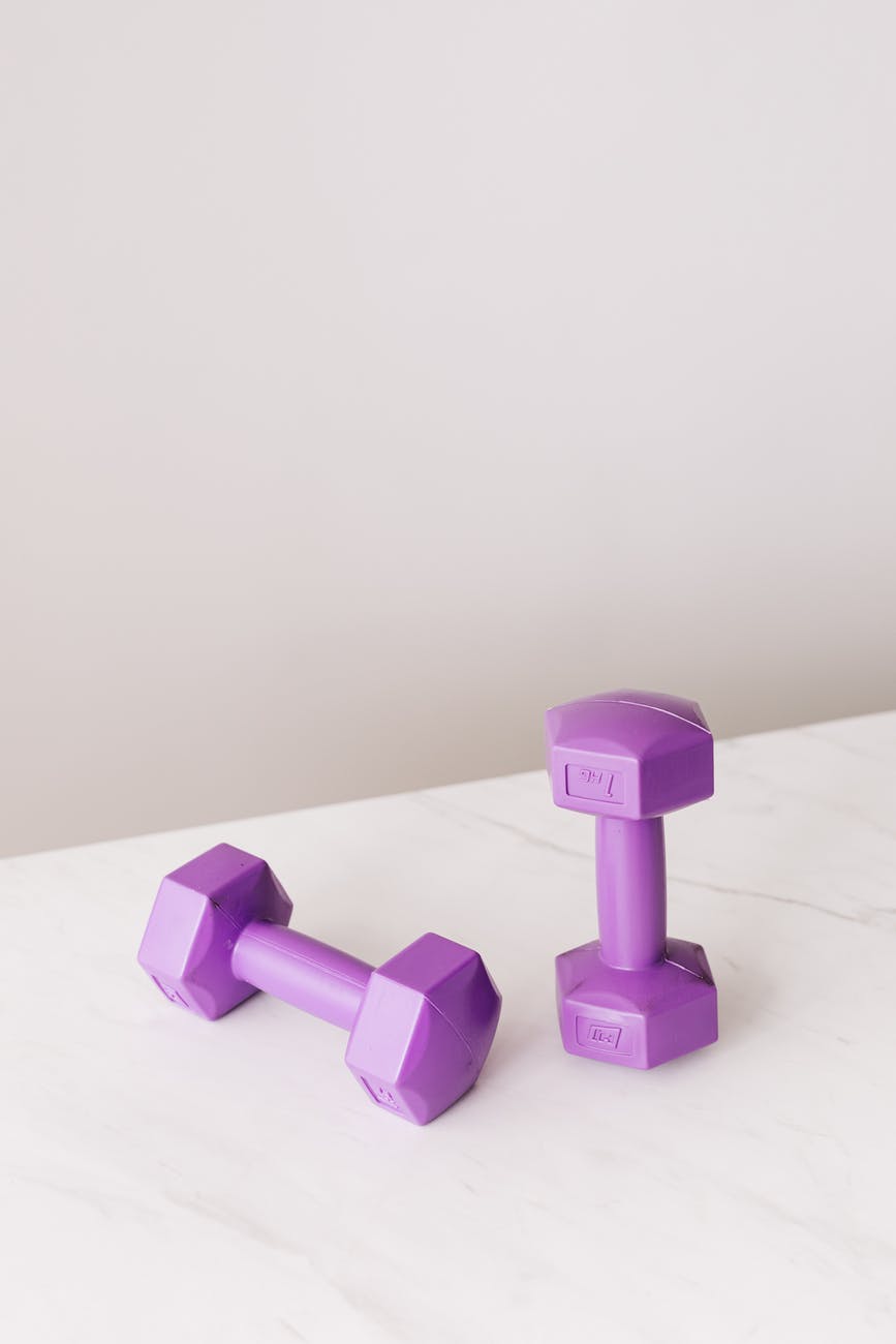 all cast dumbbell placed on marble table