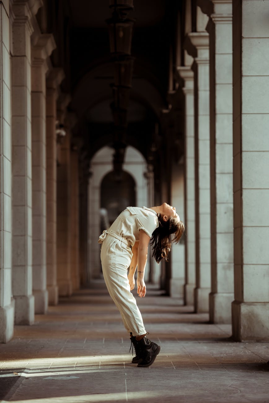 active female arching back while dancing in passage