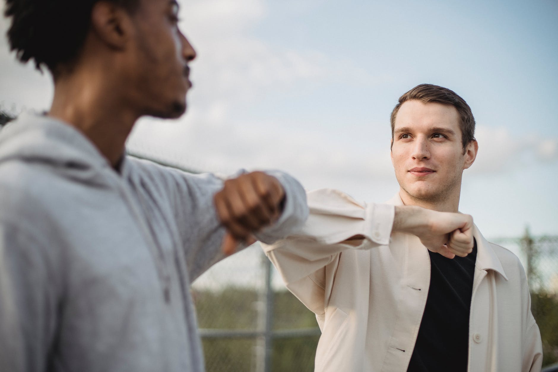 diverse friends greeting each other with elbows