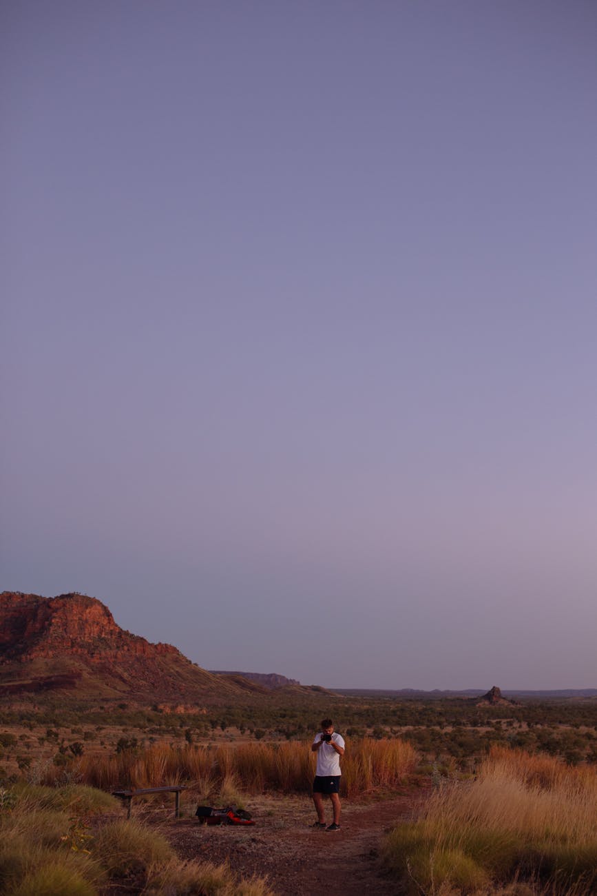 anonymous traveler standing in nature with mountain