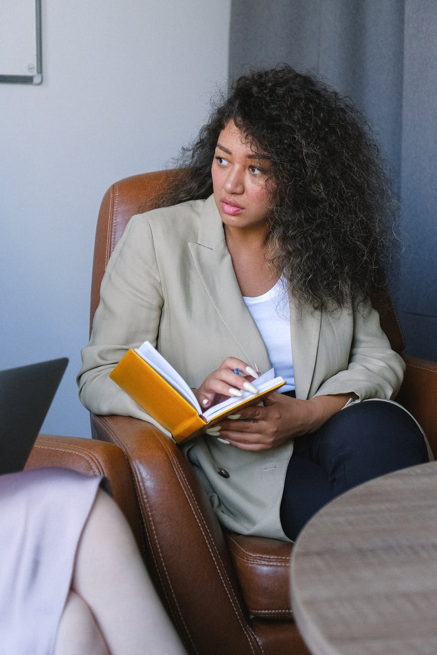 serious young woman with notebook in armchair