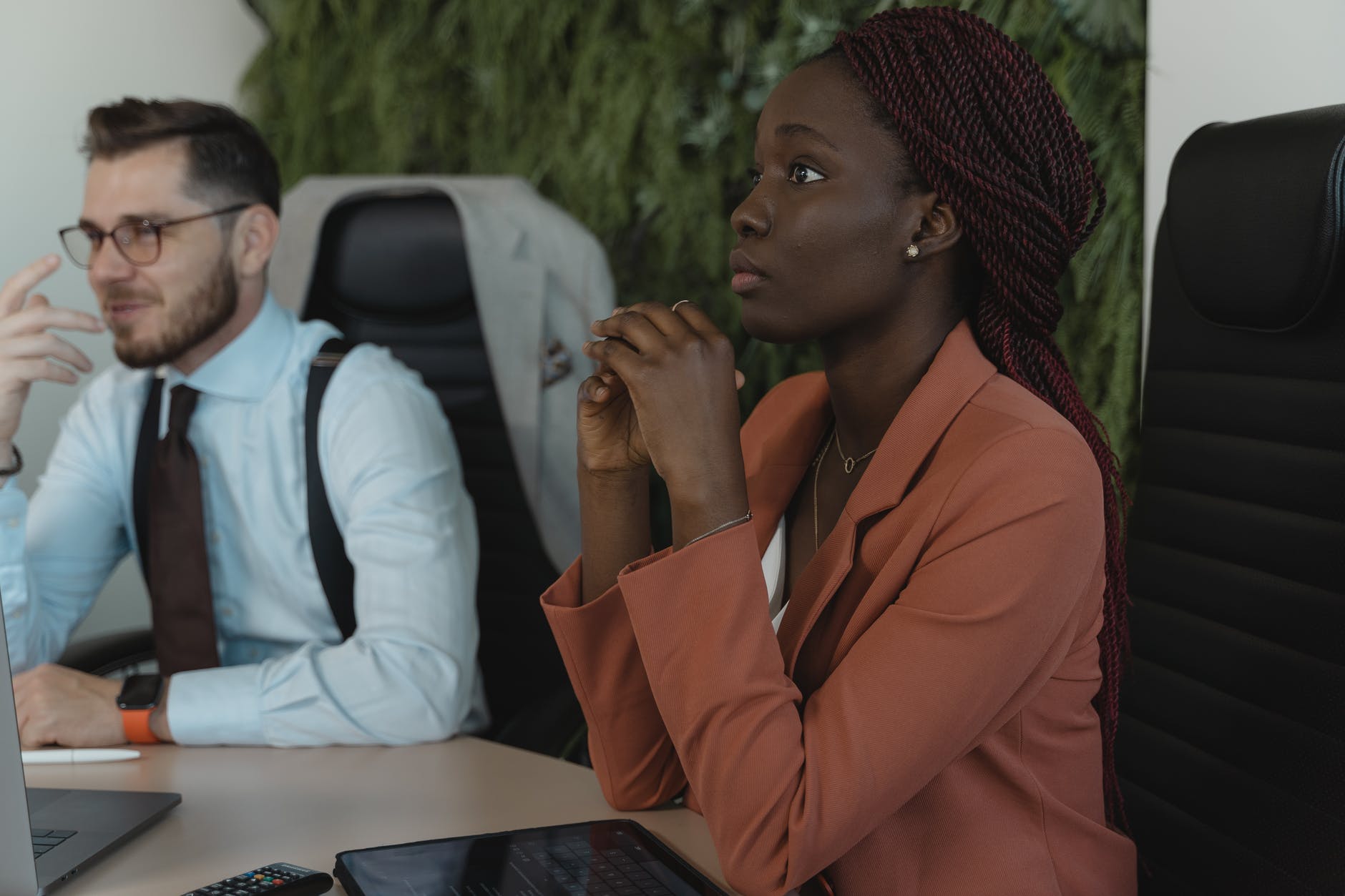 woman in brown coat sitting beside man in white dress shirt