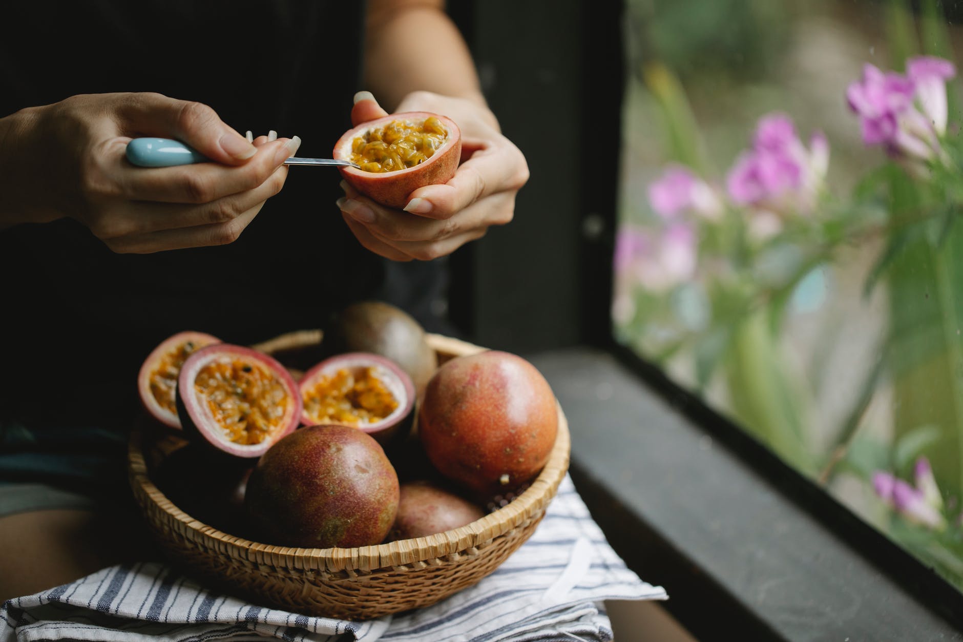 woman separating flesh of passion fruit