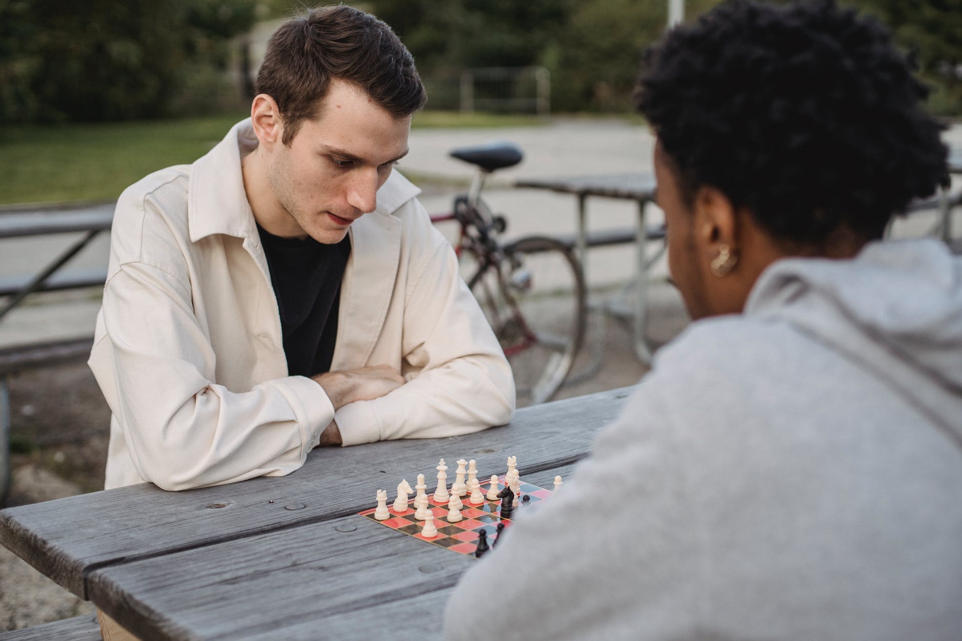 thoughtful smart young diverse men playing chess at table