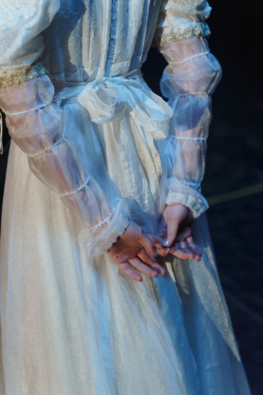 woman in white long sleeve dress with hands on her back