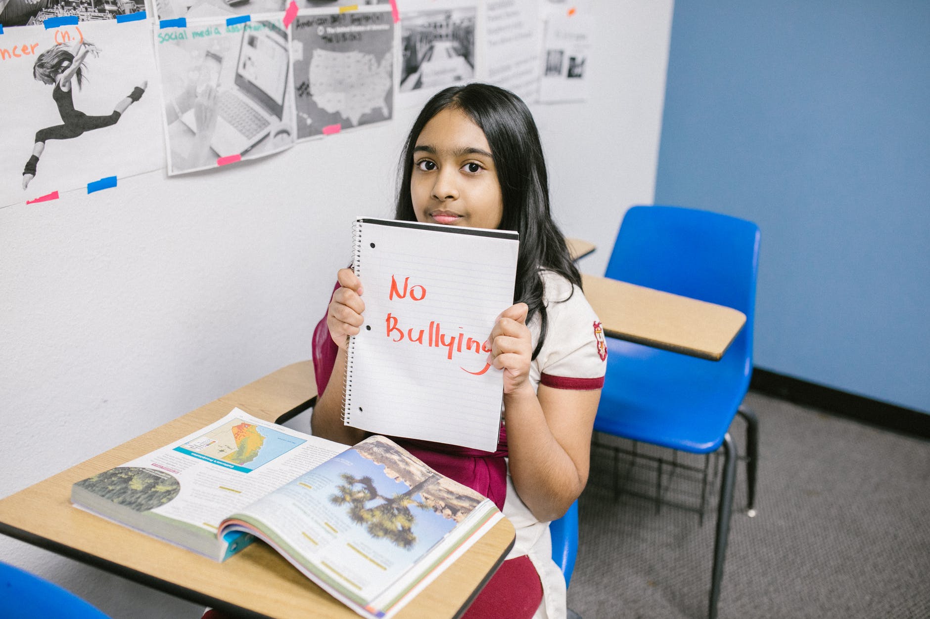 girl showing a message written in a notebook