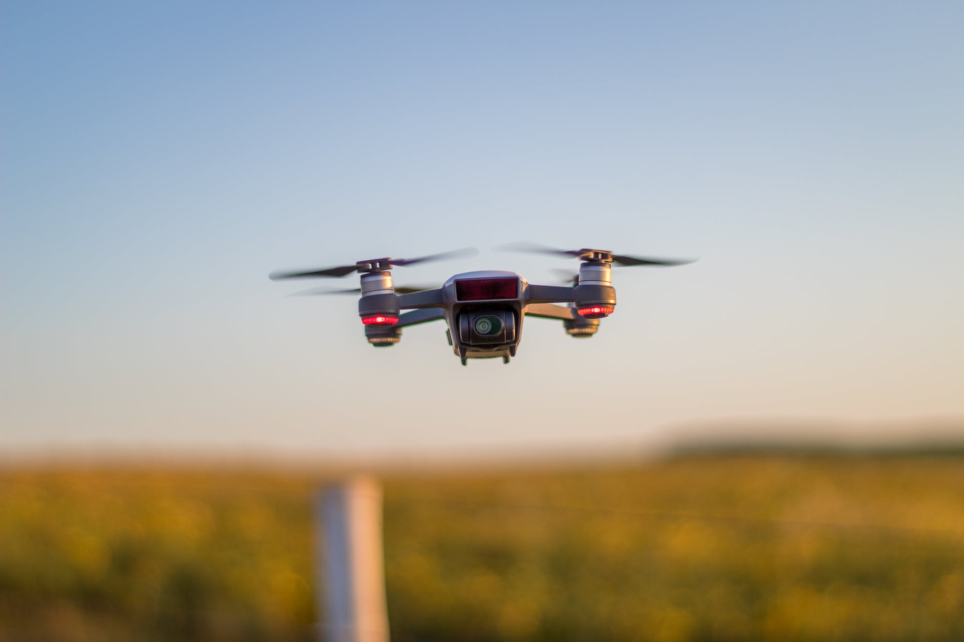 drone recording video while flying above autumn trees in countryside