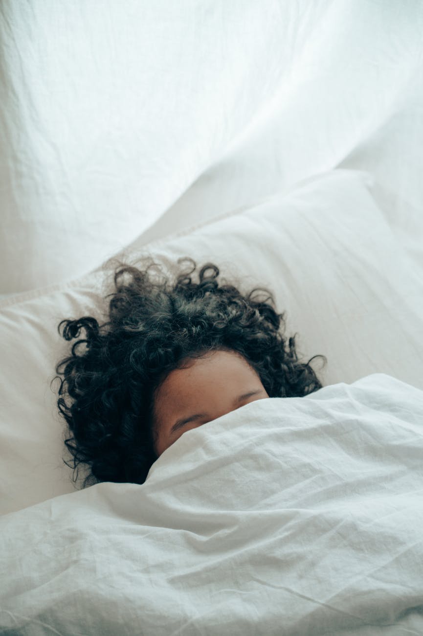 unrecognizable person sleeping under blanket