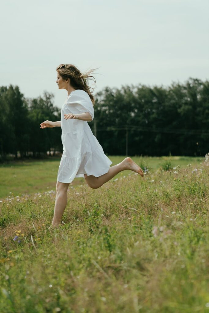 woman in white dress standing on green grass field