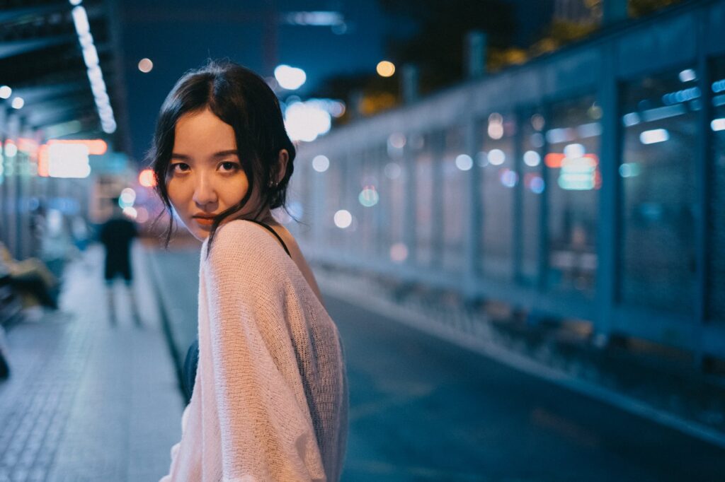 young asian woman in evening street with bright lights