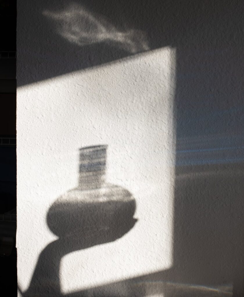 shadow of crop person with liquid in bottle