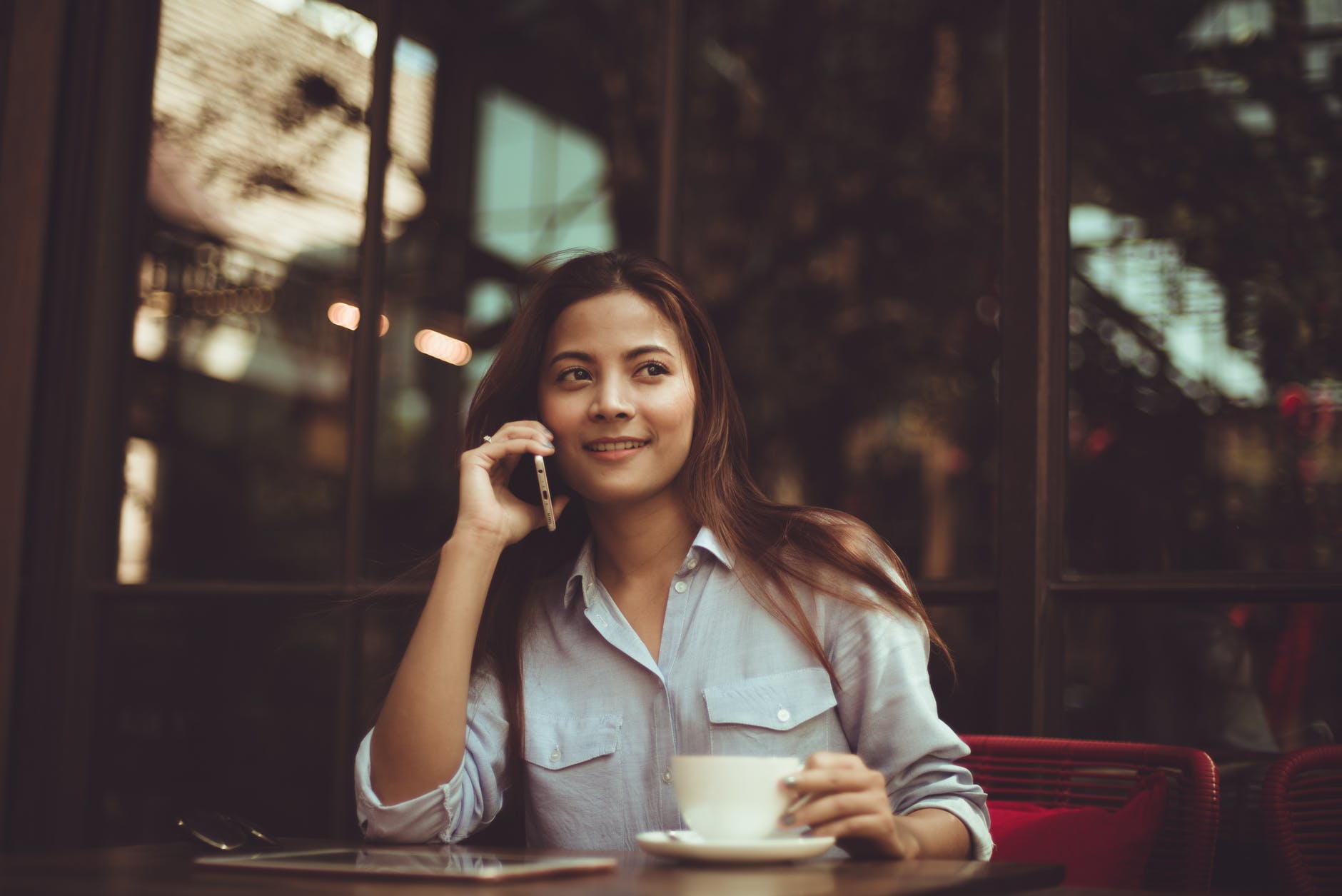 portrait of young woman using mobile phone in cafe