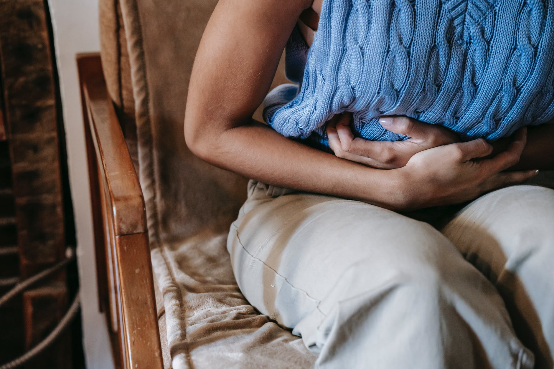 crop woman in pain on sofa