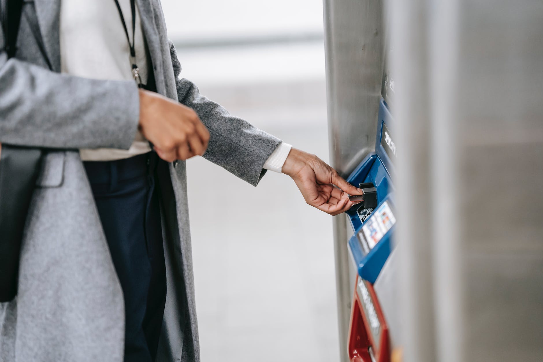 faceless woman buying metro ticket via electronic machine