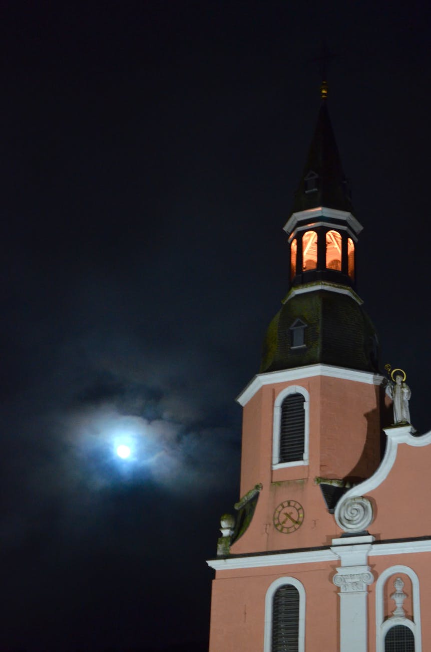 old church with bell tower under cloudy night sky