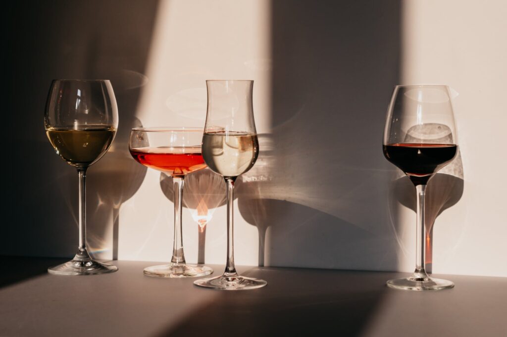 different sorts of wine in various glasses on table in sunlight