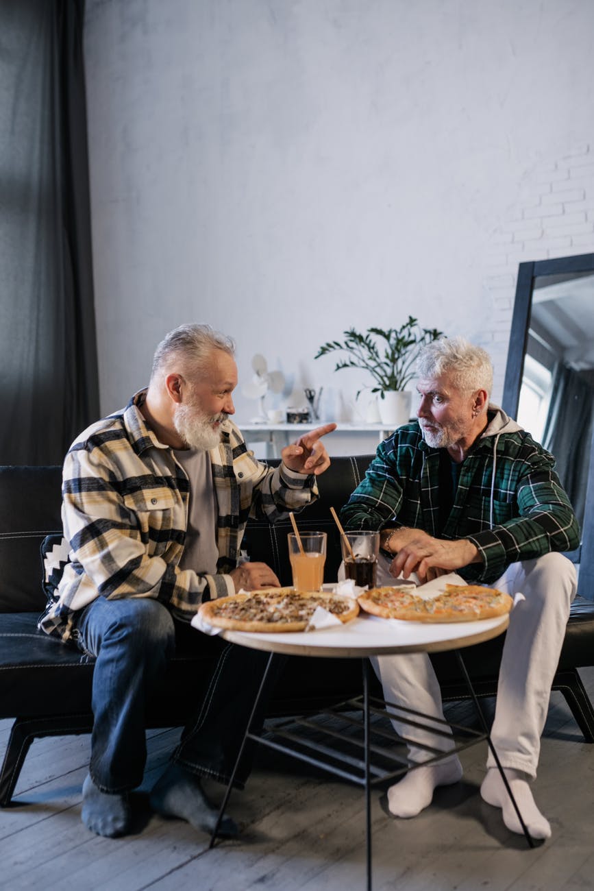 elderly men eating while talking to each other