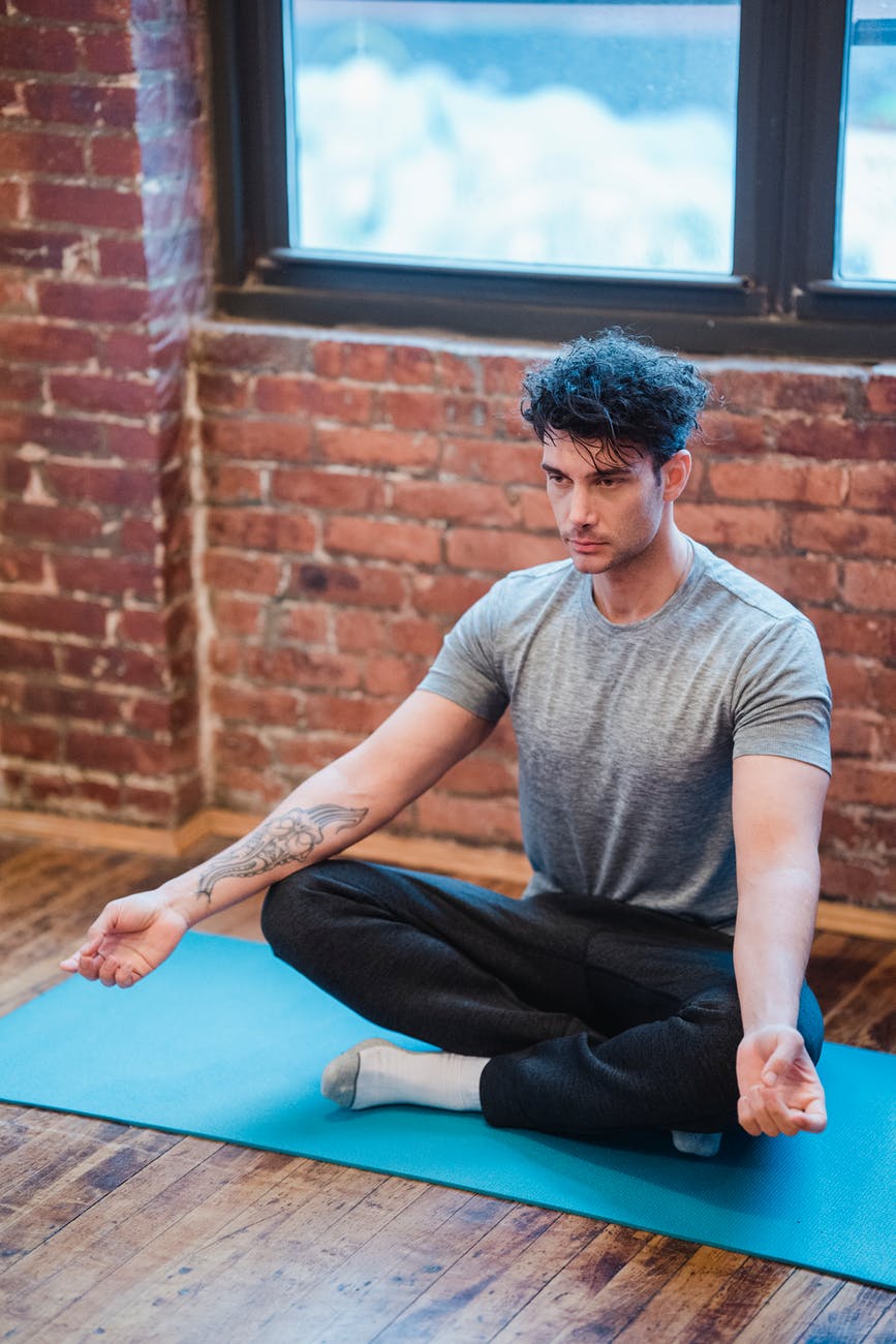 contemplative man in lotus pose on carpet