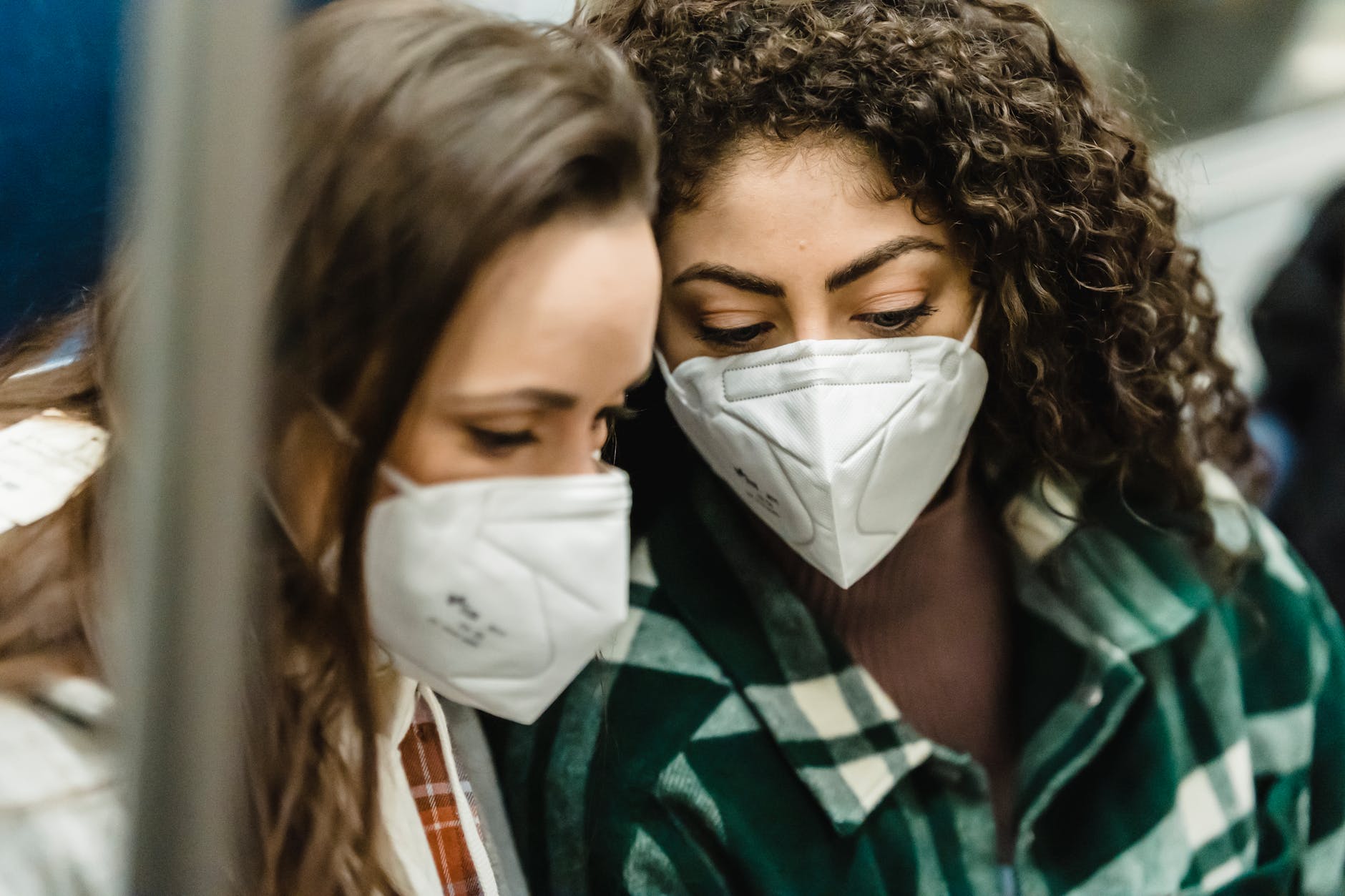 young women in medical masks riding in subway