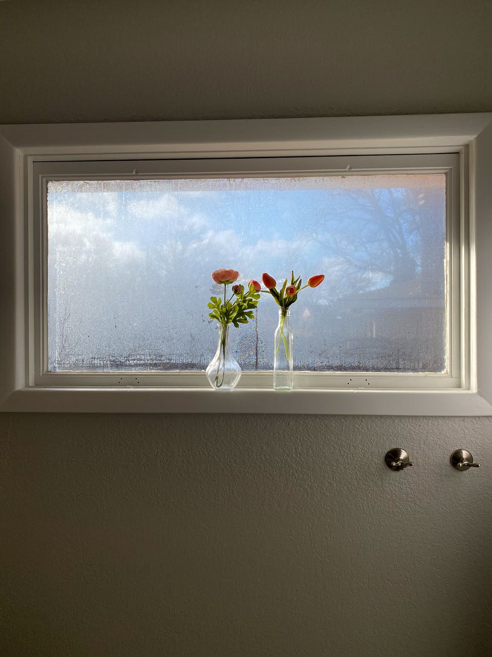 vases of fresh flowers arranged on windowsill