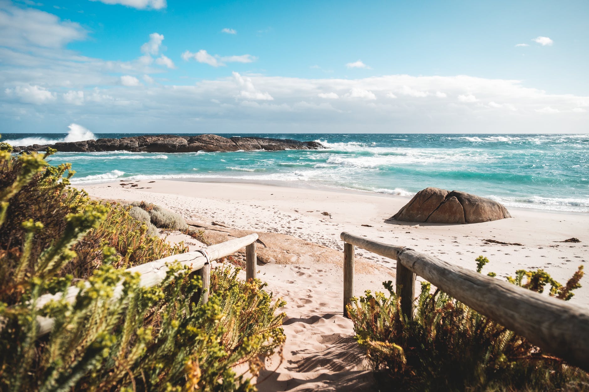 footpath with wooden railings leading to sea