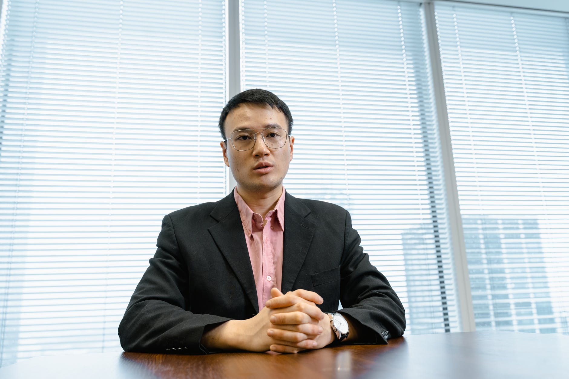 a businessman with his hands together on a desk