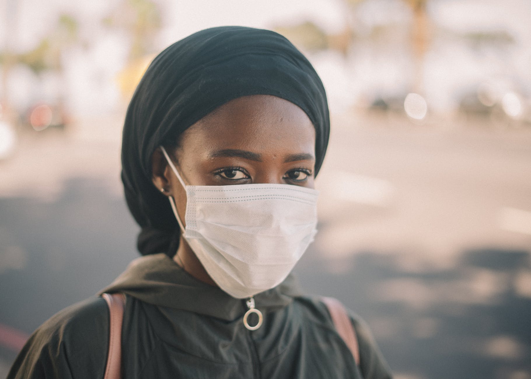 black female in medical mask on street