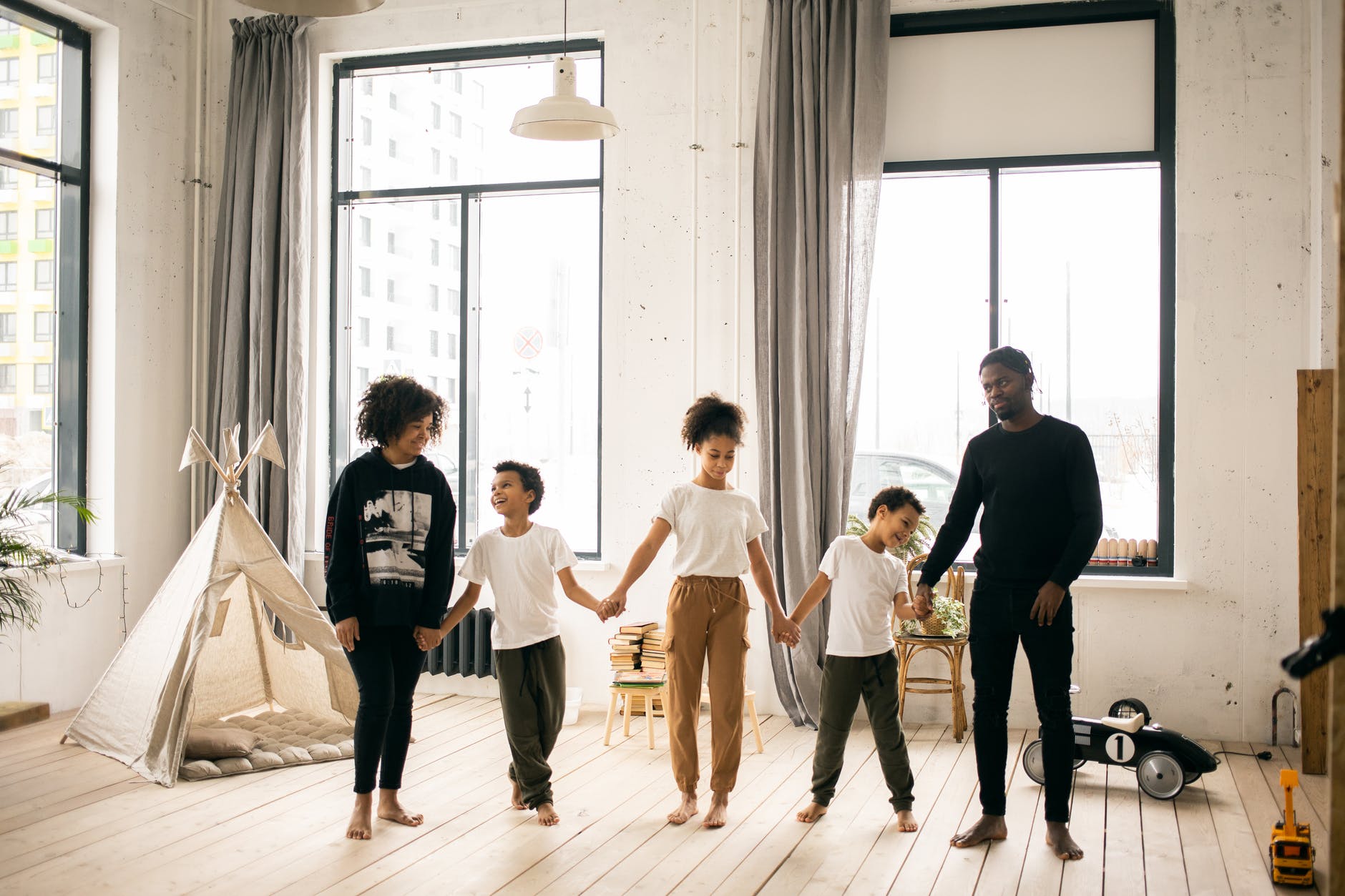 black family holding hands in room