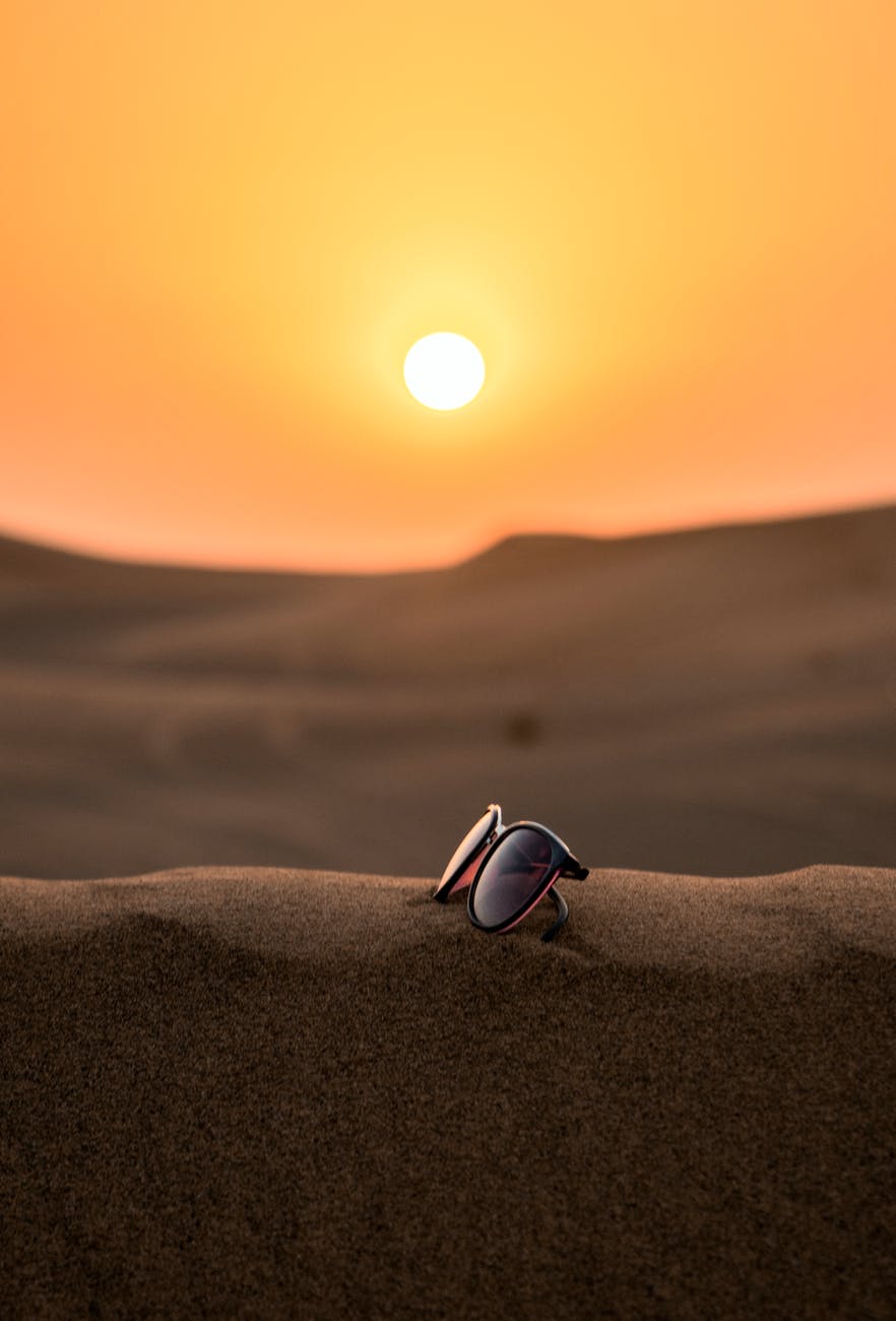 wayfarer sunglasses on sand tilt shift lens photography