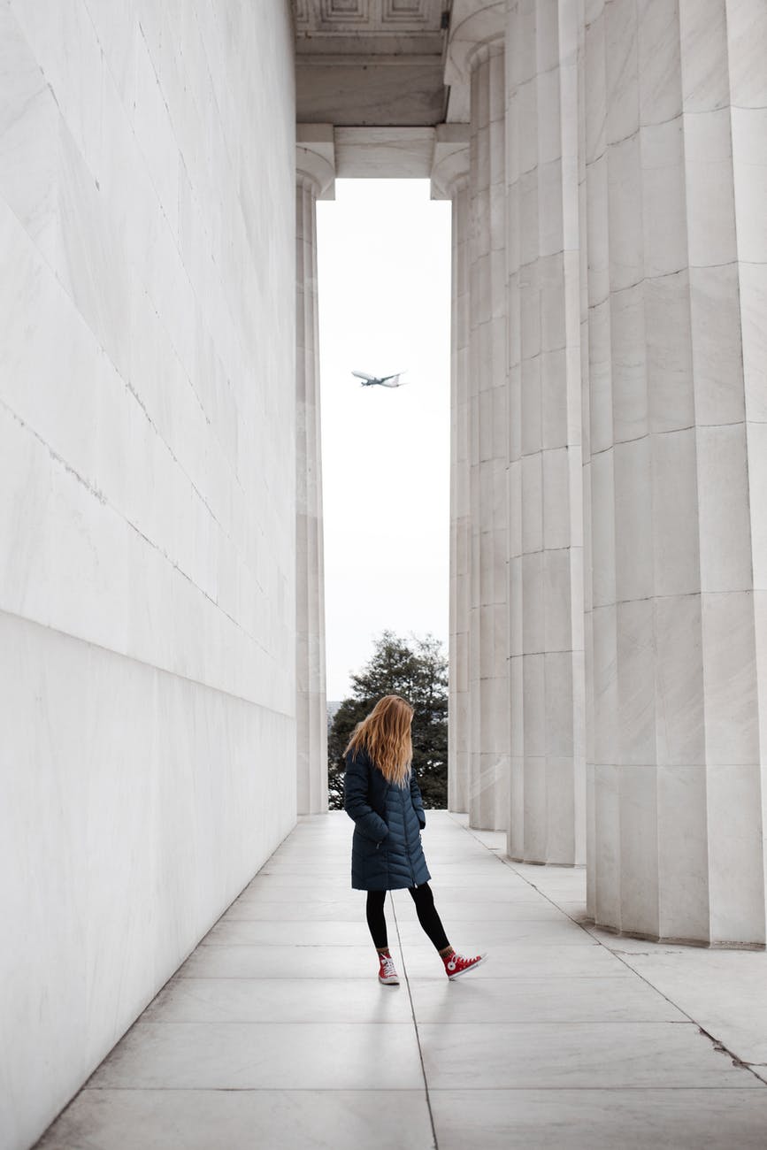 woman standing near marble pillars