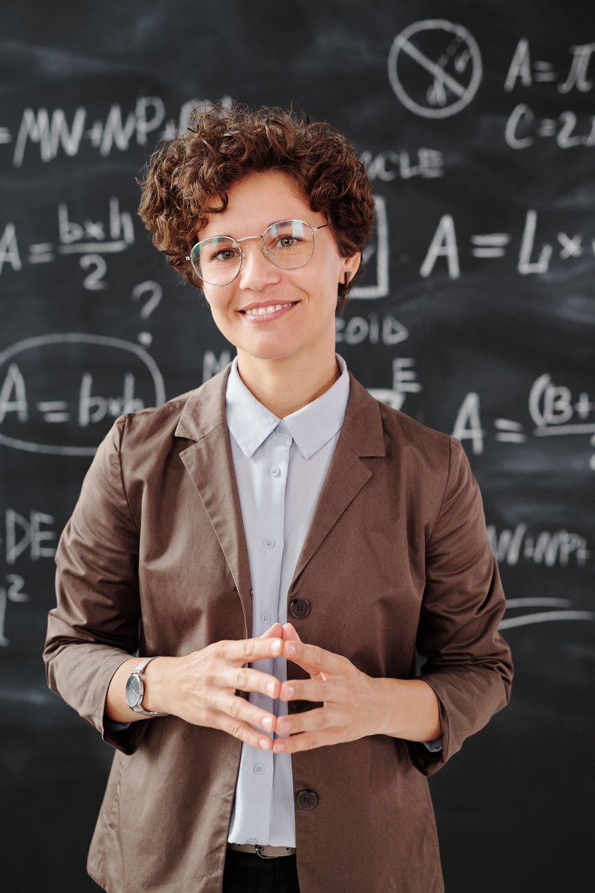 woman in brown suit jacket wearing eyeglasses