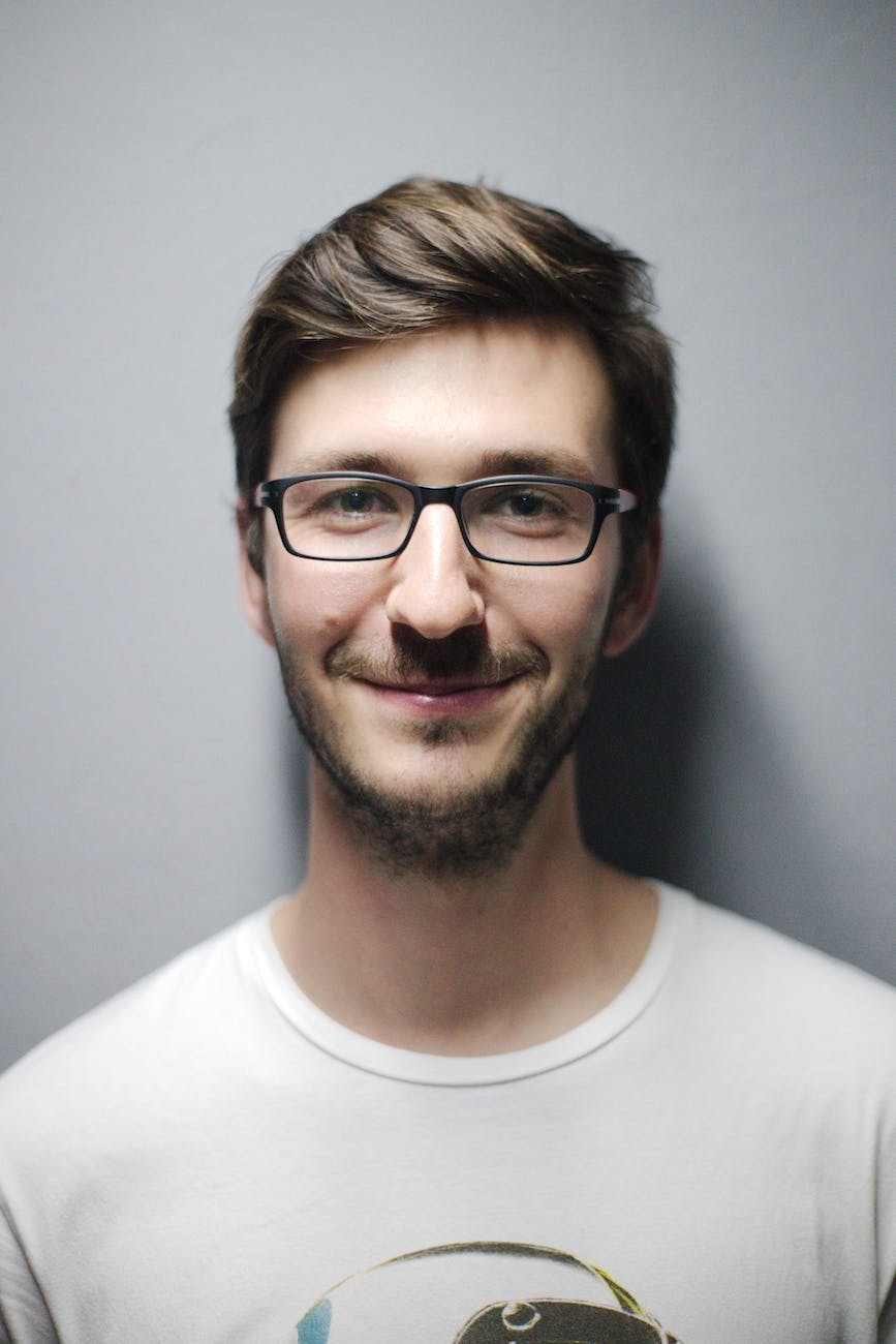 man smiling behind wall