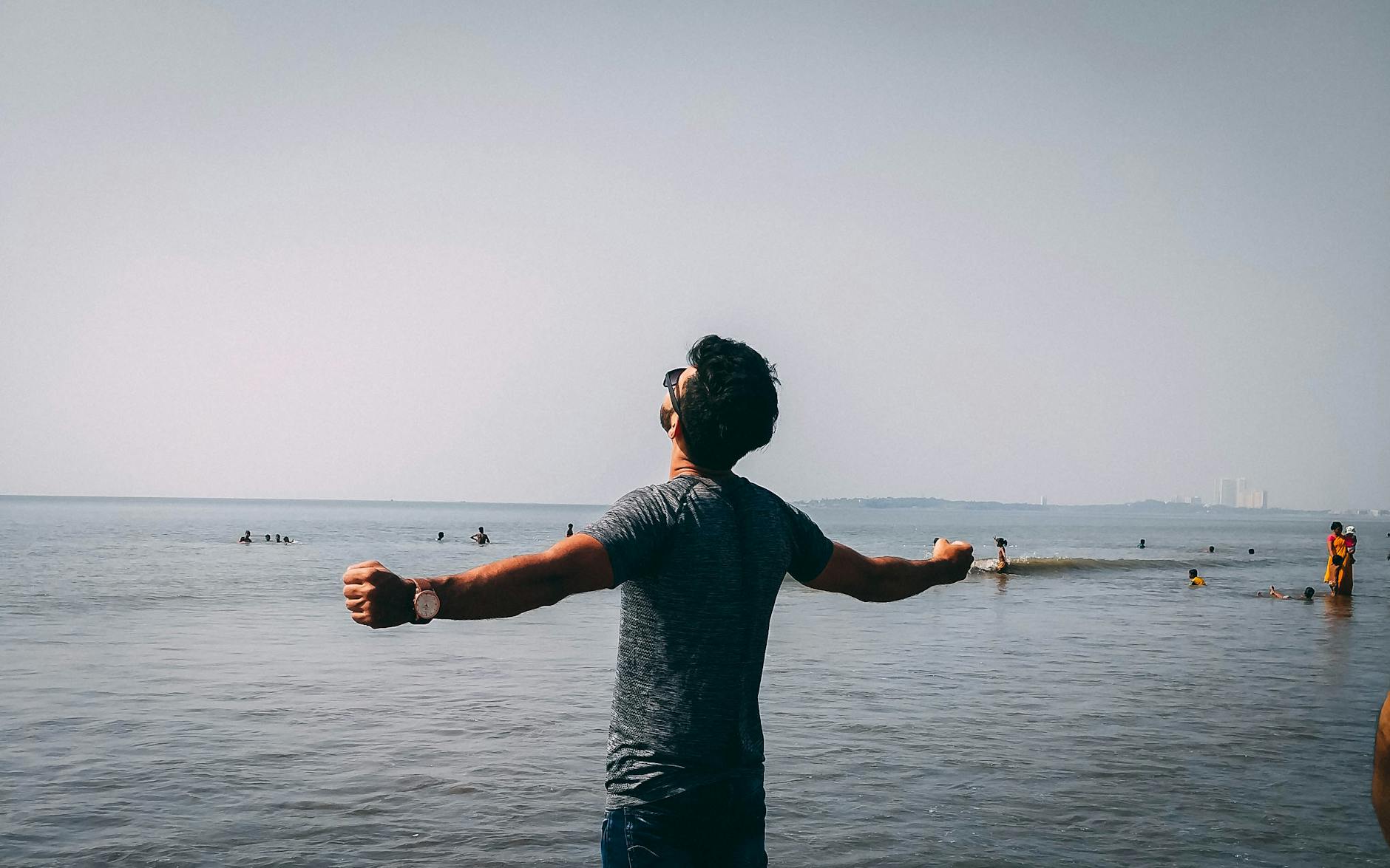 photo of man wearing gray shirt near sea